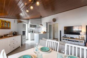 eine Küche und ein Wohnzimmer mit einem Tisch und Stühlen in der Unterkunft THE ATTIC - Caparica Beach and Surf Apartment in Costa da Caparica