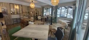 - une salle à manger avec des tables, des chaises et des fenêtres dans l'établissement Alti'Pic Hôtel, à Le Mont-Dore