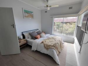 a bedroom with a large bed and a window at Lake View House entire house in Gosford