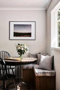 a dining room with a table and a vase of flowers at Chaplet Cottage Luxury Healesville Cottage in Healesville
