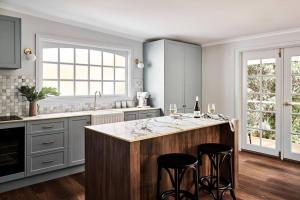 a kitchen with a large island with two bar stools at Chaplet Cottage Luxury Healesville Cottage in Healesville