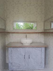 a bathroom with a sink and a mirror at Green Acres Village in Moalboal