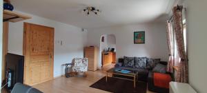 a living room with a couch and a table at Schöne helle Ferienwohnung in Eurasburg