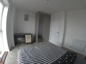 sypialnia z łóżkiem, komodą i lustrem w obiekcie RM13 x Weekly x Monthly Offers DM w mieście Dagenham