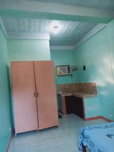 a room with a bed and a cabinet and a microwave at NatureswayBudget room Travel in Coron