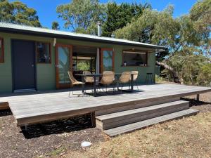 Casa con terraza de madera con mesa y sillas en Kidman's Rest, en The Range