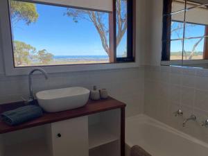 a bathroom with a sink and a tub and a window at Kidman's Rest in The Range