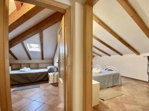 a bedroom with two beds in a room with beams at CASA FIORITA in Predaia