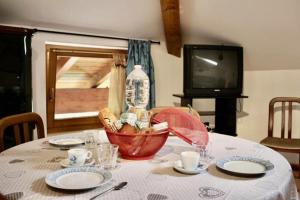 a table with a white table cloth and a bottle on it at CASA FIORITA in Predaia