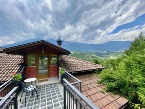 a house with a balcony with a view of the mountains at CASA FIORITA in Predaia