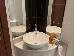 Premium 2 Bedroom Flat في المنامة: حمام مع حوض أبيض ومرآة