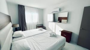 a hotel room with a bed and a mirror at Fotoxenia Luxury Apts in Paralimni