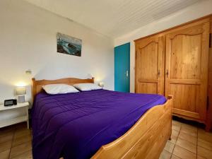 1 dormitorio con 1 cama con manta morada en Maison La Brée-les-Bains, 3 pièces, 5 personnes - FR-1-246A-181, en La Brée-les-Bains