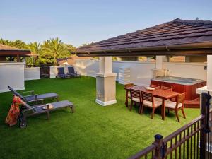 a patio with a table and chairs on the grass at Pullman Port Douglas Sea Temple Resort and Spa in Port Douglas