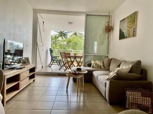 a living room with a couch and a table at Ti Kaz'ETA in Sainte-Anne