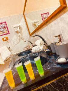 a kitchen sink with four drinking glasses on it at Petra fort hotel in Wadi Musa