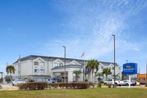 un hotel con coches aparcados delante en Baymont by Wyndham Saraland, en Saraland