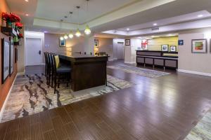 a large lobby with a bar in the middle of a room at Baymont by Wyndham Saraland in Saraland