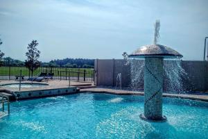 a fountain in the middle of a swimming pool at Marble Waters Hotel & Suites, Trademark by Wyndham in Jacksonville