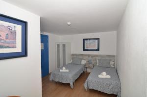 uma sala de estar com duas camas e uma mesa em Hotel Boutique Nomadas em Málaga