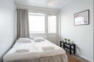 um quarto branco com uma cama grande e uma janela em 2ndhomes Tampere "Iso Ronka" Apartment - 2BR, Balcony & Great Location em Tampere