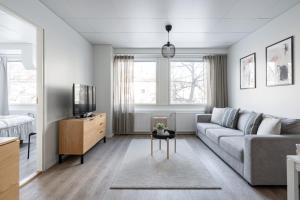 uma sala de estar com um sofá e uma televisão em 2ndhomes Tampere "Iso Ronka" Apartment - 2BR, Balcony & Great Location em Tampere