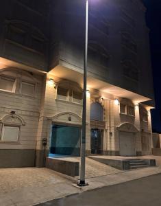 un bâtiment avec un pôle lumineux devant lui dans l'établissement H.H apartments شقق مفروشة, à La Mecque