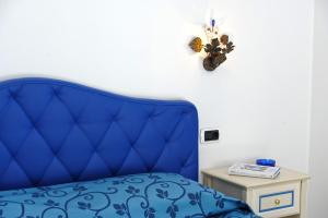 a blue bed in a room with a table at Alba di Praiano in Praiano
