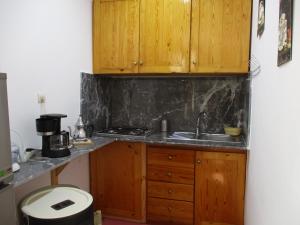 a kitchen with wooden cabinets and a sink at Dar Mozart in Essaouira