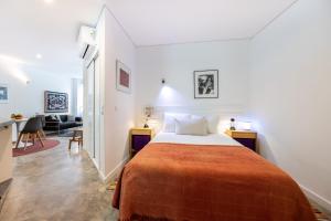 a bedroom with a bed and a living room at Perdiz do Mar in Olhão