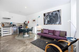 a living room with a purple couch and a table at Perdiz do Mar in Olhão