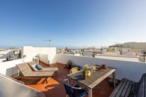 a balcony with tables and chairs on a roof at Perdiz do Mar in Olhão
