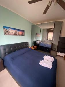 a bedroom with a large blue bed and a mirror at Fuori Milano molto tranquillo (box incluso) 