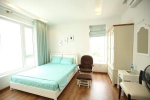 a bedroom with a bed and a chair in it at Villa Pearl FLCSầm Sơn in Sầm Sơn +10 photos