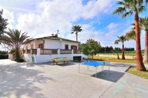 a house with a ping pong table and palm trees at Villa Can Mussol 040 by Mallorca Charme in Sa Pobla