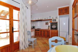 a kitchen with wooden cabinets and a table and chairs at Villa Can Mussol 040 by Mallorca Charme in Sa Pobla