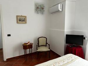 una camera con letto, sedia e televisore di Home Marty a Napoli
