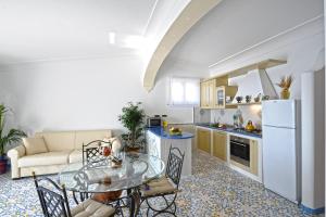 uma cozinha e sala de estar com uma mesa e um sofá em Alba di Praiano em Praiano