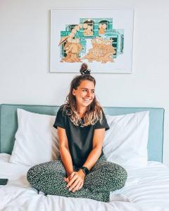 a woman sitting on top of a bed at Hotel 171 in Rotterdam