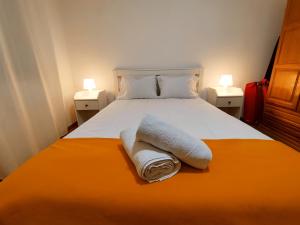 um quarto com uma cama com duas toalhas em The Whale Beach House em Atouguia da Baleia