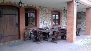 a wooden table and chairs on a patio at Hostel Miłosz in Grabowiec