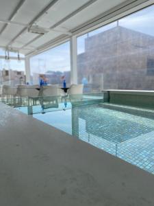 a swimming pool with tables and chairs in a building at Mamma Mia Hotel Boutique - Only Adults in Tossa de Mar
