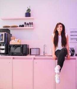 a woman sitting on top of a counter in a kitchen at 171. Urban Design Hotel in Rotterdam