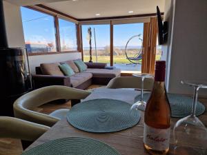 a bottle of wine sitting on a table in a living room at Luxury Reed House in Balatonudvari