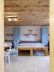 1 dormitorio con 1 cama, mesa y sillas en Penzion - Vinařství Hanuš, en Blučina