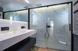 埃斯托利爾的住宿－Deluxe Monte Estoril，一间带玻璃淋浴和水槽的浴室