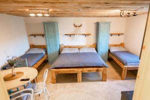 um quarto com duas camas e uma mesa em Penzion - Vinařství Hanuš em Blučina
