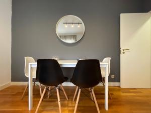 mesa de comedor con 2 sillas negras y espejo en Apartments City Center • Collection by Perpetual Relax en Braga