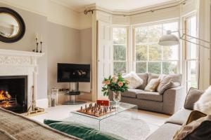 a living room with a couch and a fireplace at Somerley House + Hut & Hot Tub in Lowestoft