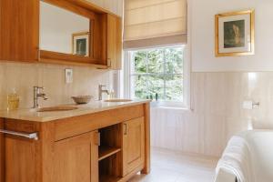 un bagno con un lavandino, uno specchio e una finestra di Somerleyton Meadows - Somerley House plus Hut & Hot Tub a Lowestoft Altre 68 foto
